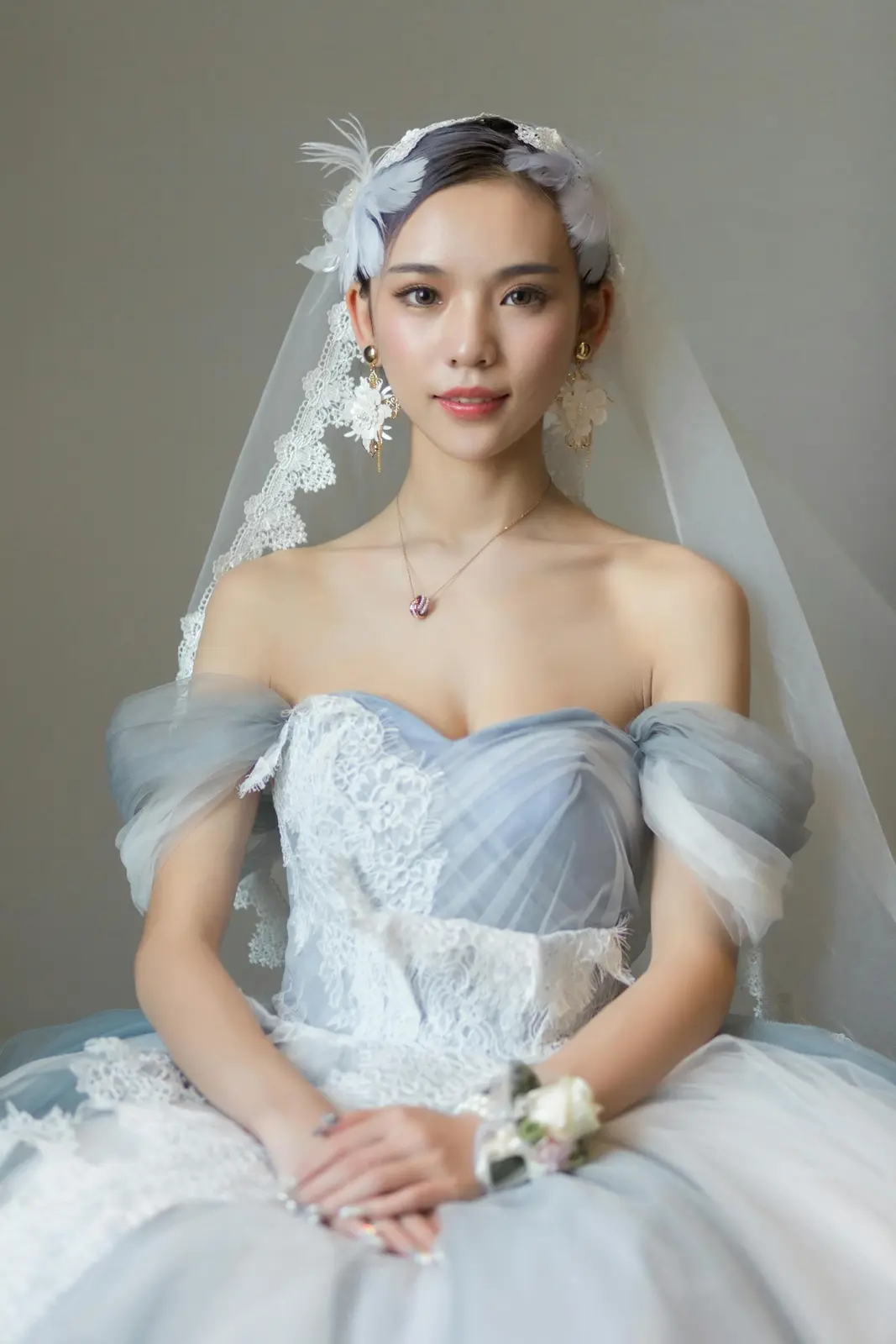 Close-up of a bride holding a lush bouquet against a textured wall