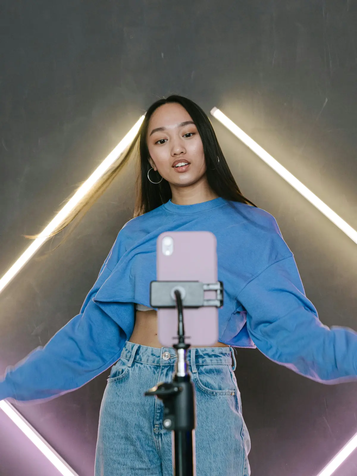 Esports player posing with gaming headset under neon lighting