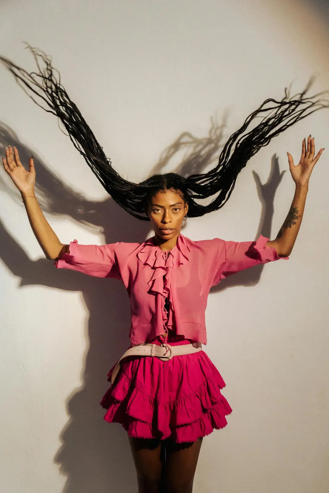 Runway-inspired pose highlighting statement tailoring against a designer set